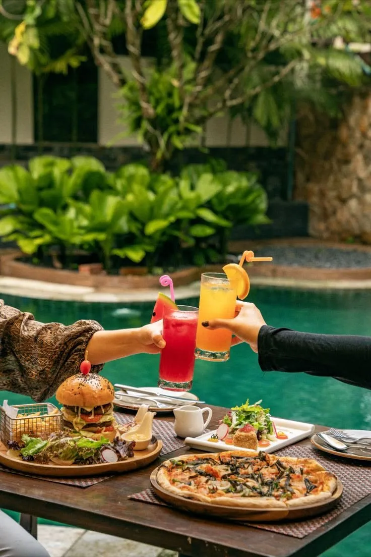 Guests toasting with drinks by the pool